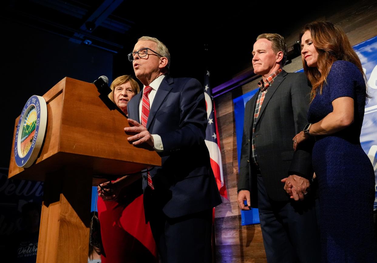 Gov. Mike DeWine, joined by First Lady Fran DeWine, left, Lt. Gov. Jon Husted, second from right, and Second Lady Tina Husted, right, addresses supporters during a primary election victory party at his campaign headquarters in May.