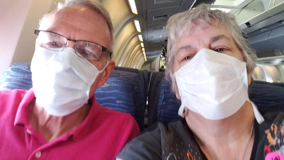 Rob and Andrea Anderson take a selfie on an airplane on Friday, April 3. They are finally headed home after being quarantined in their room on a cruise ship for more than a week.