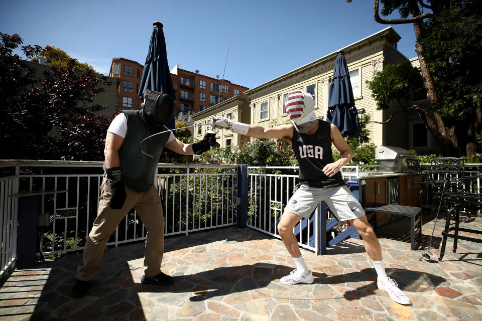 SAN FRANCISCO, CALIFORNIA - MAY 15:  Alexander Massialas (right) trains with his father and coach, Greg Massialas, on their back porch on May 15, 2020 in San Francisco, California. Alexander was on the 2012 and 2016 US Olympic Fencing Team and had planned on being in Tokyo this summer for the 2020 Summer Olympics. He won the silver medal in individual foil and a bronze medal in the team event at the 2016 Olympics. Greg was a member of the 1980, 1984, and 1988 US Olympic Team and is now the national coach for the United States foil team.  Athletes across the globe are now training in isolation under strict policies in place due to the Covid-19 pandemic.  Massialas is now focused on staying in shape and getting ready for the Olympics in Tokyo in 2021.  (Photo by Ezra Shaw/Getty Images)