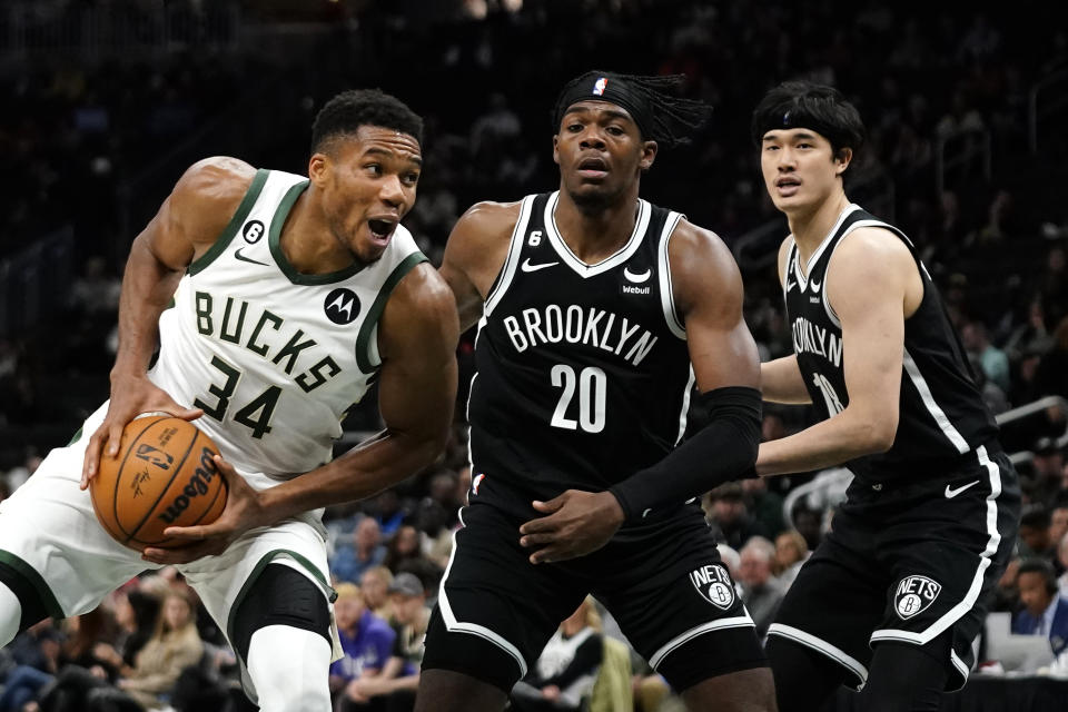 Milwaukee Bucks' Giannis Antetokounmpo (34) drives to the basket against Brooklyn Nets' Day'Ron Sharpe (20) and Yuta Watanabe during the second half of an NBA preseason basketball game Wednesday, Oct. 12, 2022, in Milwaukee. (AP Photo/Aaron Gash)