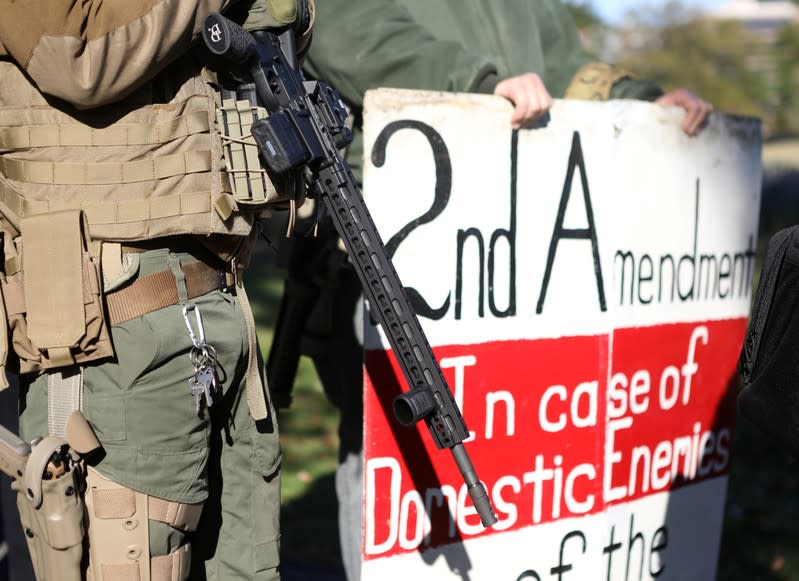 A man carries a rifle as militia members and pro-gun rights activists participating in the "Declaration of Restoration" rally prepare to march to Washington, D.C. from Arlington, Virginia