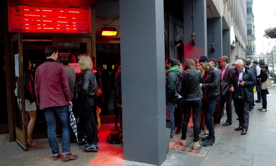 FOR STORY DINING DELAYS - Customers form a queue as they wait to be seated in the Meat Liquor restaurant on Welbeck Street in central London, around 20:30 on Tuesday, July 10, 2012, which is currently one of London's busiest destinations for burgers and cocktails. The Meat Liquor restaurant has a no-booking policy which means queues often form outside as customers wait to sample the food and the atmosphere at one of the capital's most sought after destinations, but people have to arrive together if they want to be seated together. (AP Photo/Joel Ryan)