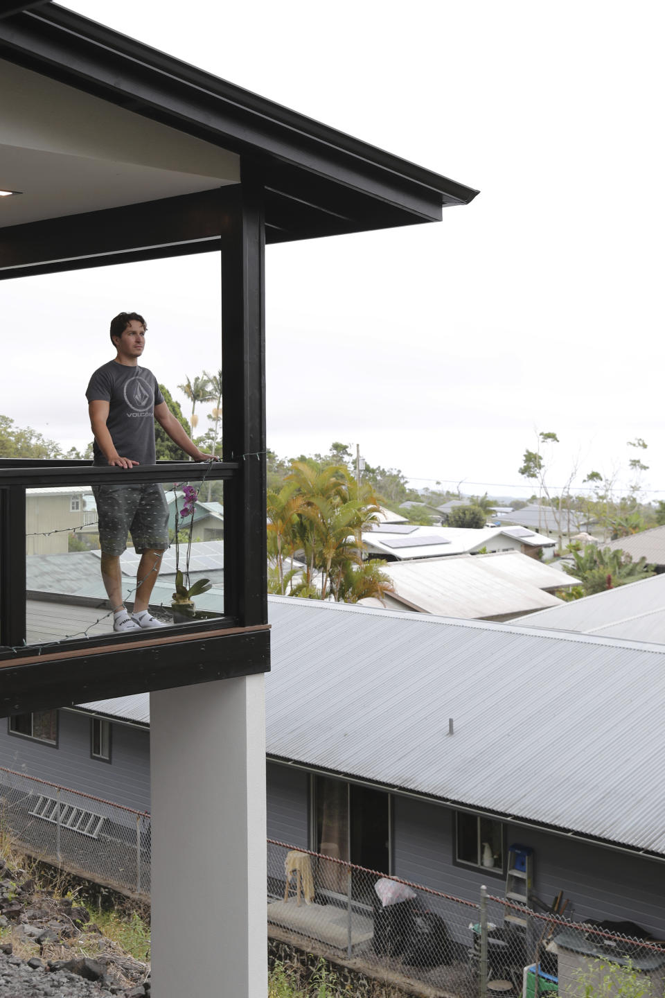 Tom Schneider over looks his neighborhood from his balcony, Tuesday, Nov. 29, 2022, in Hilo, Hawaii. (AP Photo/Marco Garcia)