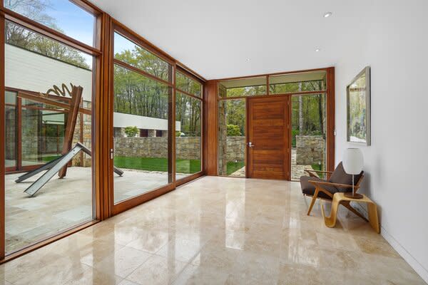 Wood-encased, floor-to-ceiling windows frame striking sculpture views near the entrance.