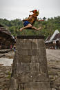 NIAS ISLAND, INDONESIA - FEBRUARY 24: A villager wearing traditional costume jumps over a stone in front of their ancient houses in Orahili Fau village on February 24, 2013 in Nias Island, Indonesia. Stone Jumping is a traditional ritual, with locals leaping over large stone towers, which in the past resulted in serious injury and death. Stone jumping in Nias Island was originally a tradition born of the habit of inter tribal fighting on the island of Nias. (Photo by Ulet Ifansasti/Getty Images)