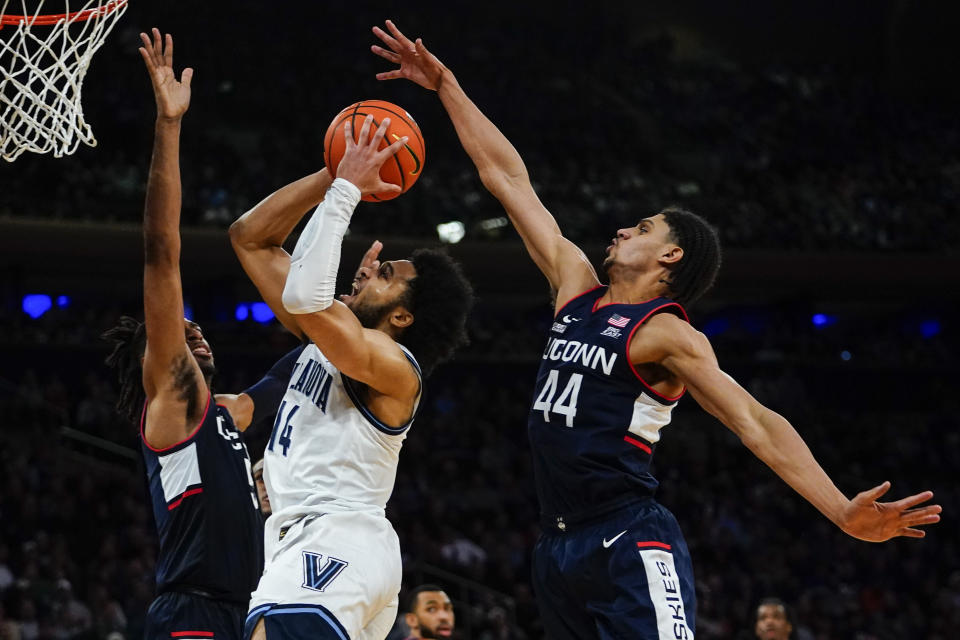 Connecticut's Isaiah Whaley, left, and Andre Jackson, right, defend against Villanova's Caleb Daniels during the first half of an NCAA college basketball game in the semifinal round of the Big East conference tournament Friday, March 11, 2022, in New York. (AP Photo/Frank Franklin II)