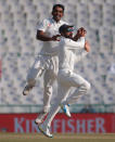 Cricket - India v England - Third Test cricket match - Punjab Cricket Association Stadium, Mohali, India - 26/11/16. India's captain Virat Kohali and Jayant Yadav (L) celebrates the dismissal of England's Joe Root. REUTERS/Adnan Abidi