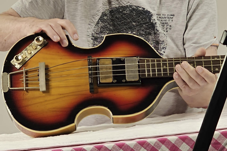 In this photo released by The Lost Bass Project/Nick Wass on Friday, Feb. 16, 2024, Nick Wass, an executive with Hoefner, inspects Paul McCartney bass. A bass stolen from Paul McCartney more than 50 years ago has been found and returned to the Beatle. A woman living on England's south coast came forward after word spread last year about the search for the missing 1961 violin-shaped Hoefner bass. McCartney's website said Thursday that the instrument was authenticated by the manufacturer and the musician is incredibly grateful to those who helped find it. (The Lost Bass Project/Nick Wass via AP)