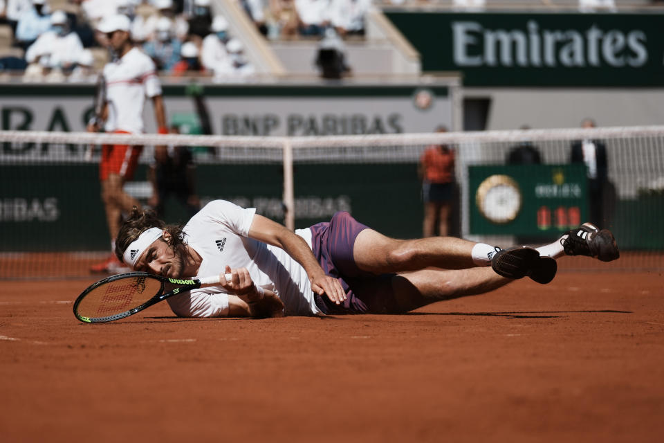 Stefanos Tsitsipas of Greece falls on the clay as he plays Serbia's Novak Djokovic during their final match of the French Open tennis tournament at the Roland Garros stadium Sunday, June 13, 2021 in Paris. (AP Photo/Thibault Camus)