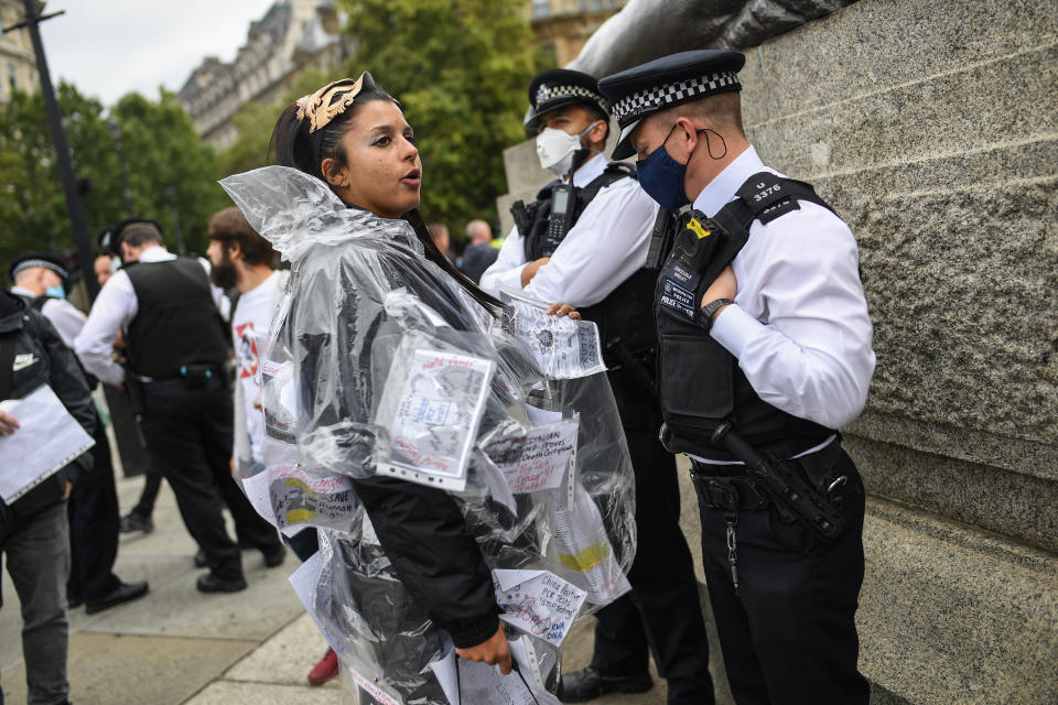 A female protester stands in front of police.