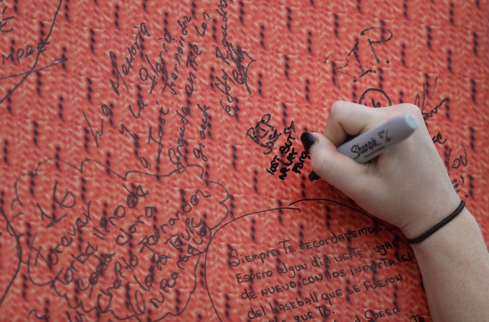 <p>A person signs a memorial wall as they wait for the hearse carrying Miami Marlins pitcher Jose Fernandez to pass in front of the Marlins baseball stadium on September 28, 2016 in Miami, Florida. Mr. Fernandez was killed in a weekend boat crash in Miami Beach along with two friends. (Photo by Joe Raedle/Getty Images) </p>