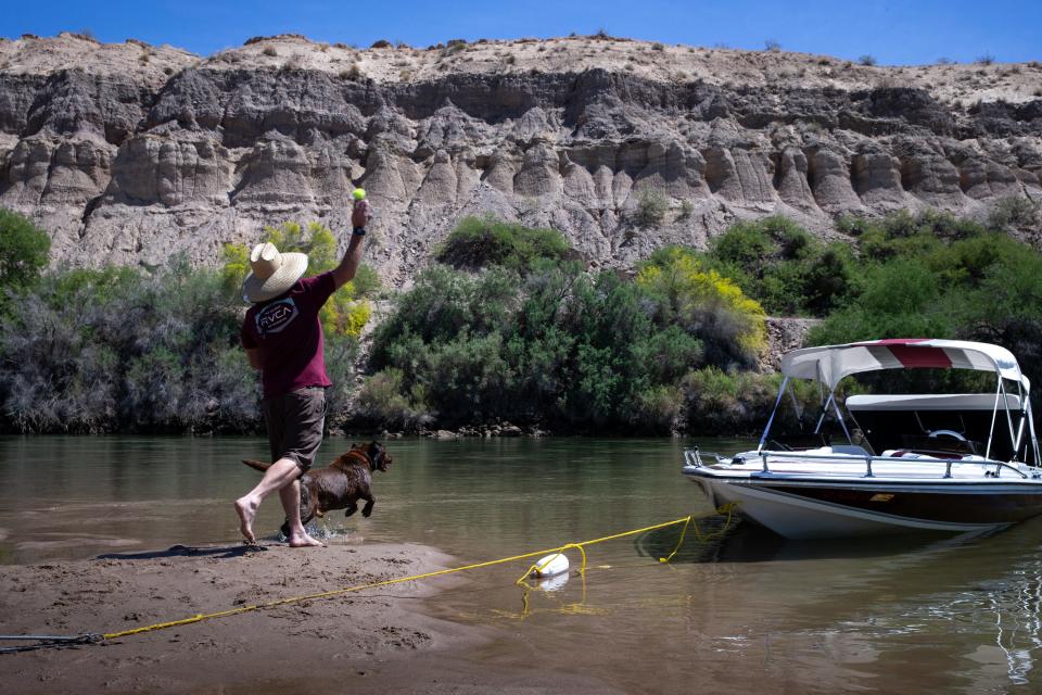 Larry Shufelt throws a ball for his dog, Snickers, on April 16, 2021, from a sandbar on the Colorado River, north of Cibola, Arizona.