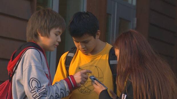 Teens stand outside Maaqtusiis Secondary School in Ahousaht, B.C. in January 2020, just months before a global pandemic was declared. (Chris Corday/CBC - image credit)