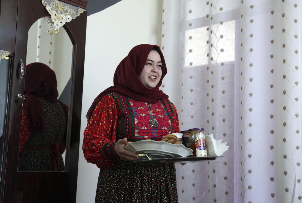 In this Sunday, Oct. 14, 2018 photo, Hameeda Danesh, a candidate for Parliament, serves breakfast in her home, before an interview with The Associated Press, in Kabul, Afghanistan. Danesh was locked away at age 13 and beaten daily for six months by uncles who abhorred the thought of her attending school. Now, she’s running for a seat in Parliament hoping to guarantee education for the next generation of Afghan girls, despite threats from the Taliban and outraged government-aligned warlords. (AP Photo/Rahmat Gul)