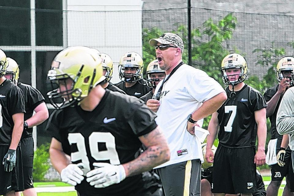 Offensive coordinator Brent Davis directs his players at the opening of Army football preseason camp in West Point.