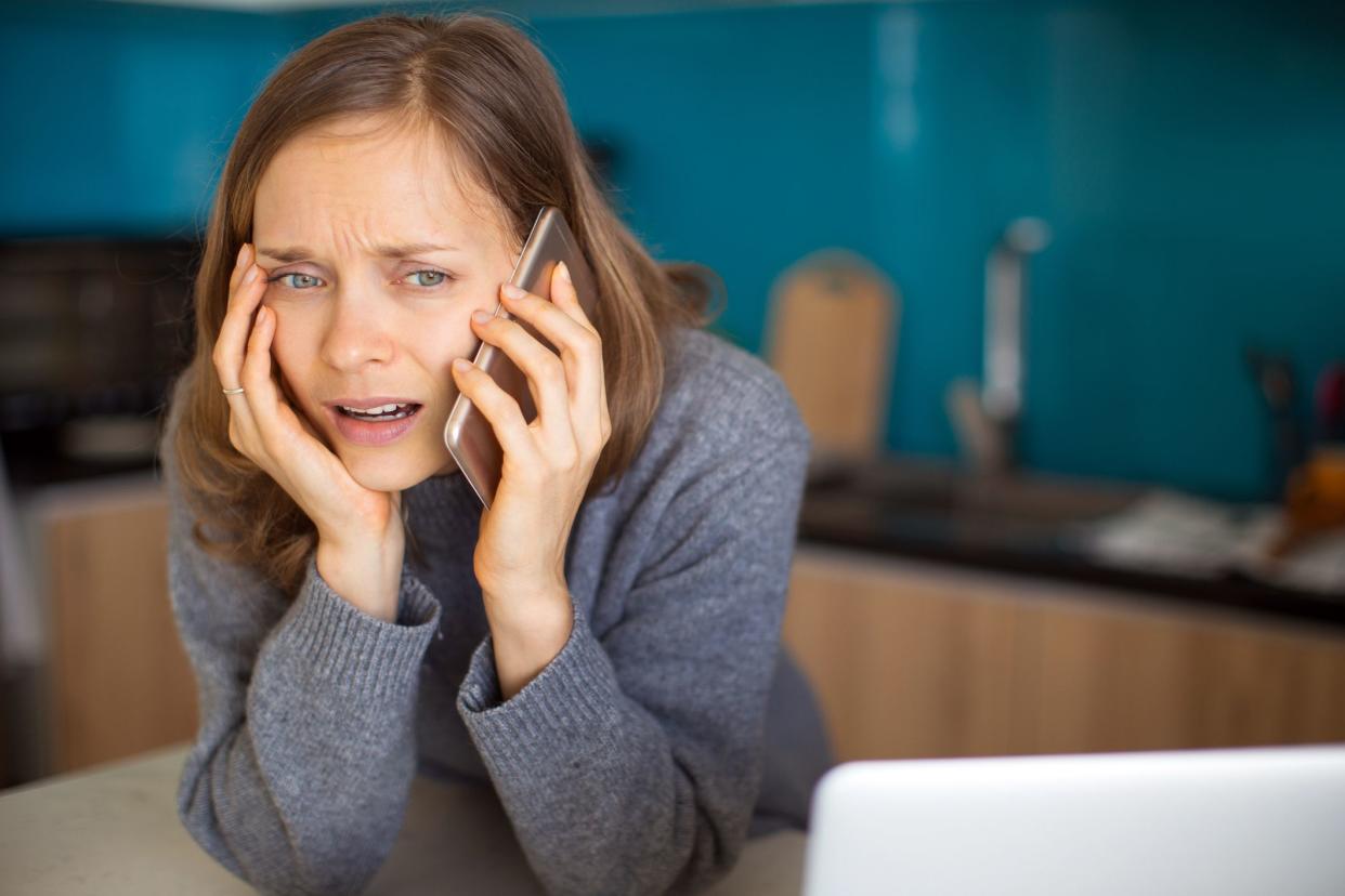 woman looking surprised and upset on phone