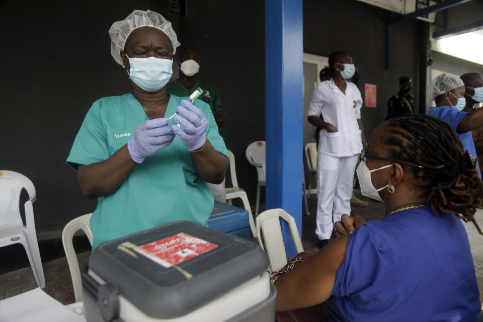 FILE - In this March 12, 2021, file photo, a woman waits to receives one of the country's first coronavirus vaccinations manufactured by the Serum Institute of India and provided through the global COVAX initiative, at Yaba Mainland hospital in Lagos, Nigeria. The stark vaccine access gap is prompting increased calls across the world for the U.S. to start shipping vaccine supplies to poorer countries. (AP Photo/Sunday Alamba, File)