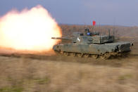 A Japanese Ground-Self Defense Force (JGDDF) Type 90 tank fires while advancing on a target during an annual exercise at the Minami Eniwa Camp Tuesday, Dec. 7, 2021, in Eniwa, Japan's northern island of Hokkaido. Dozens of tanks are rolling over the next two weeks on Hokkaido, a main military stronghold for a country with perhaps the world's most little known yet powerful army. (AP Photo/Eugene Hoshiko)WLD