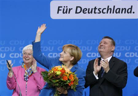 German Chancellor and leader of Christian Democratic Union (CDU) Angela Merkel is applauded by Gerda Hasselfeldt, head of the faction of Christian Social Union (CSU) in Berlin (L) and CDU party secretary general Hermann Groehe after first exit polls in the German general election (Bundestagswahl) at the CDU party headquarters in Berlin September 22, 2013. REUTERS/Fabrizio Bensch