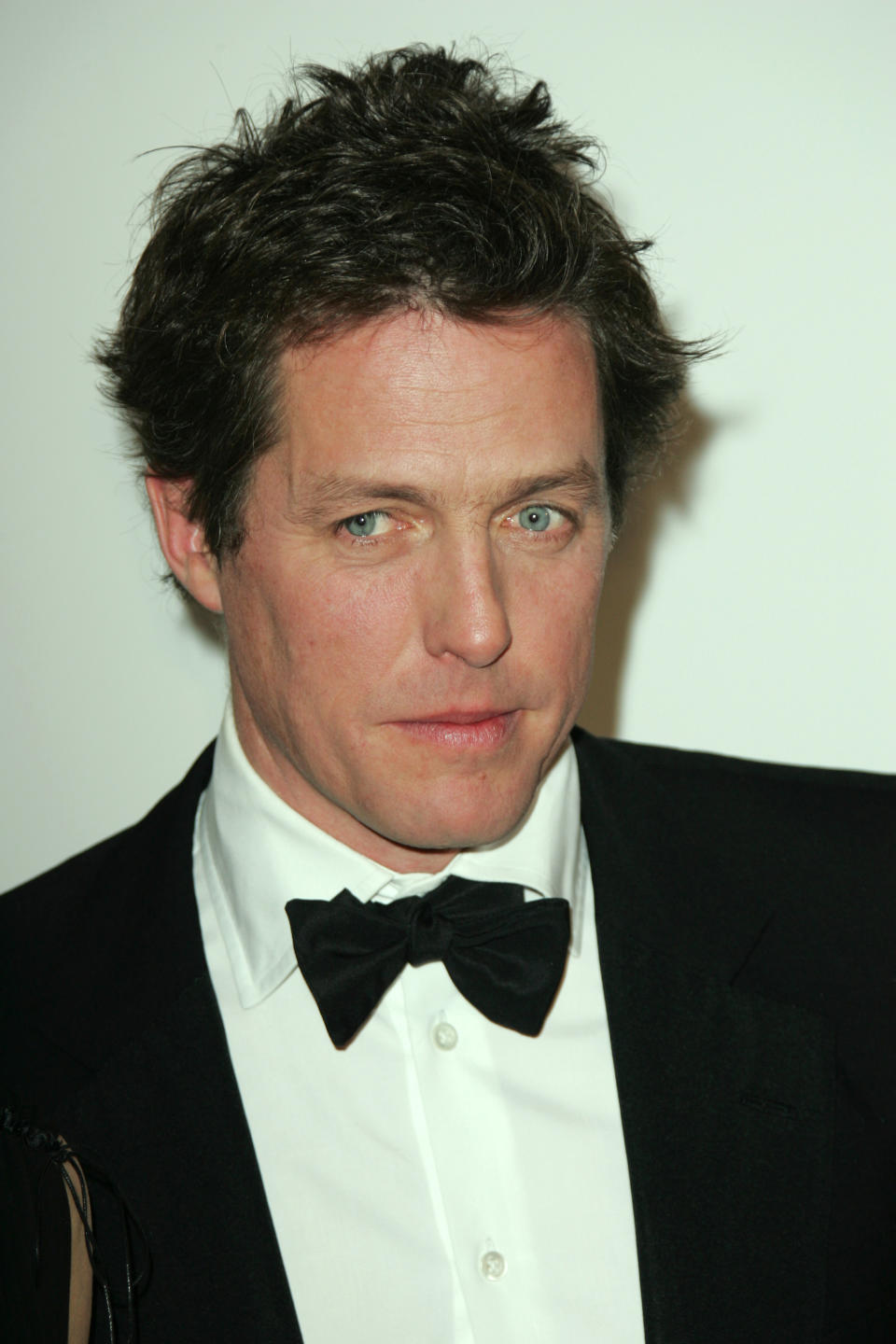 Celebrity Hugh Grant in a classic tuxedo with a bow tie at a formal event