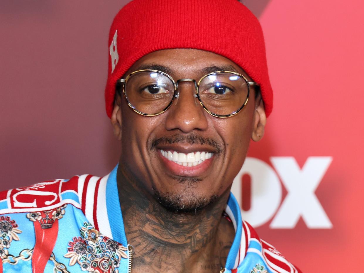 Nick Cannon wearing a patterned blue shirt and a bright red headband at the Fox Upfront in New York City.