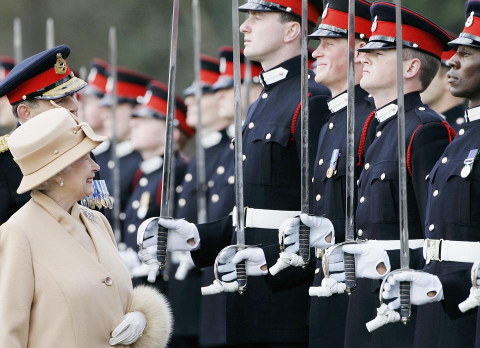 Queen Elizabeth II  smiles at Prince Harry as she inspects soldiers at their passing-out Sovereign's Parade 