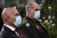 Army Gen. Gustave Perna, who is leading Operation Warp Speed, right, and Dr. Moncef Slaoui, chief adviser to Operation Warp Speed, listen during at an event in the Rose Garden of the White House, Friday, Nov. 13, 2020, in Washington. (AP Photo/Evan Vucci)