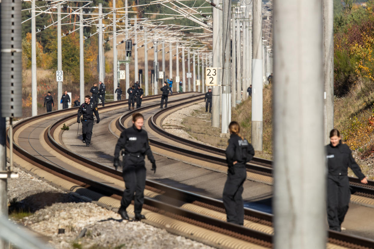 Polizisten suchen am 31.10.2018 nach dem Fund des Stahlseils auf der ICE-Strecke zwischen Nürnberg und München die Schienen ab (Bild: dpa)