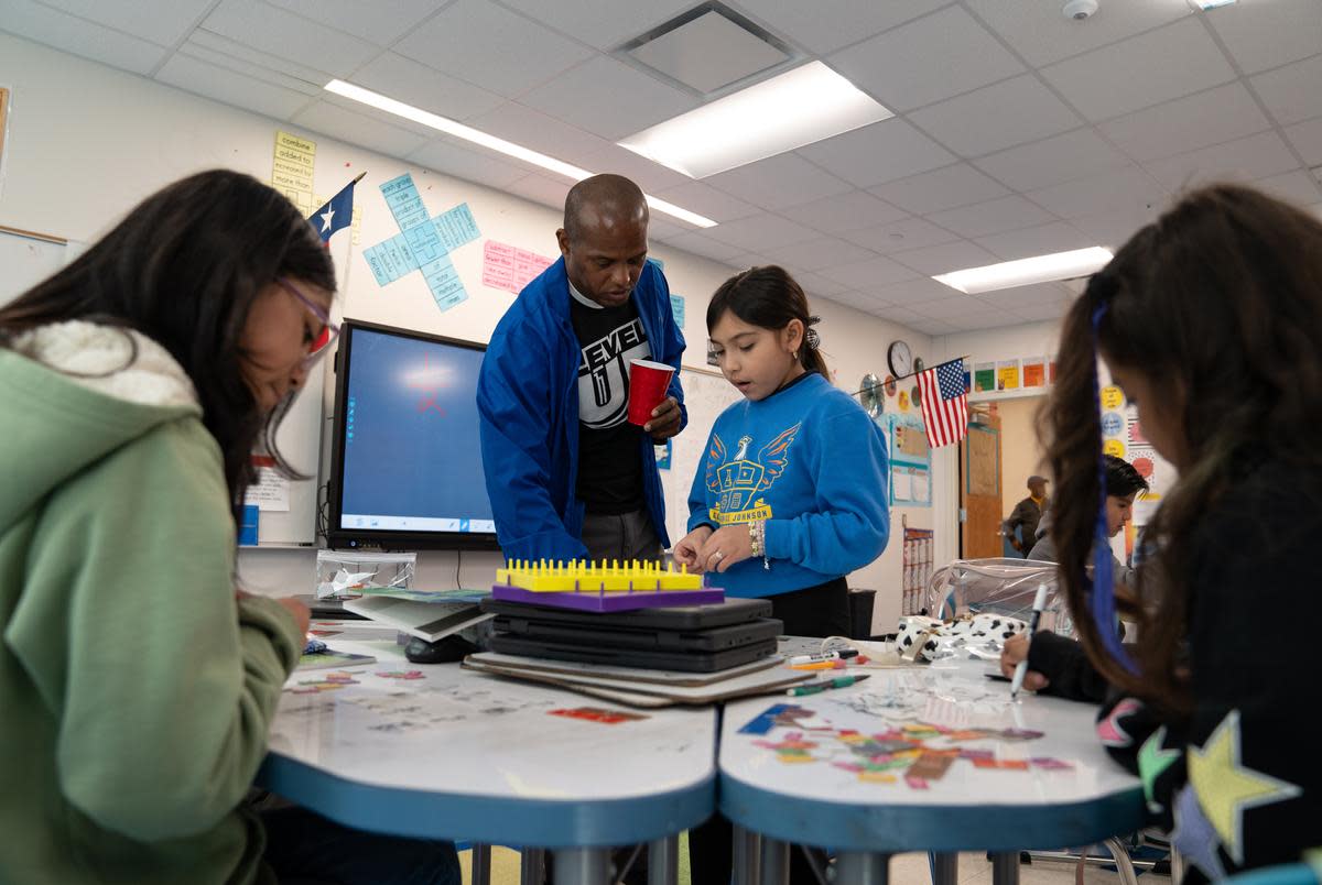 Third grade teacher Eran McGowan helps students work through math problems at the Eddie Bernice Johnson STEM Academy in Dallas, Texas on Feb. 5, 2024.