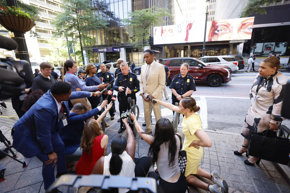 Atlanta Mayor Andre Dickens, center, speaks during a news conference with Atlanta Police Chief Darin Schierbaum, center left, Tuesday, June 11, 2024, outside a food court where multiple people were shot and injured in downtown Atlanta. (Miguel Martinez/Atlanta Journal-Constitution via AP)