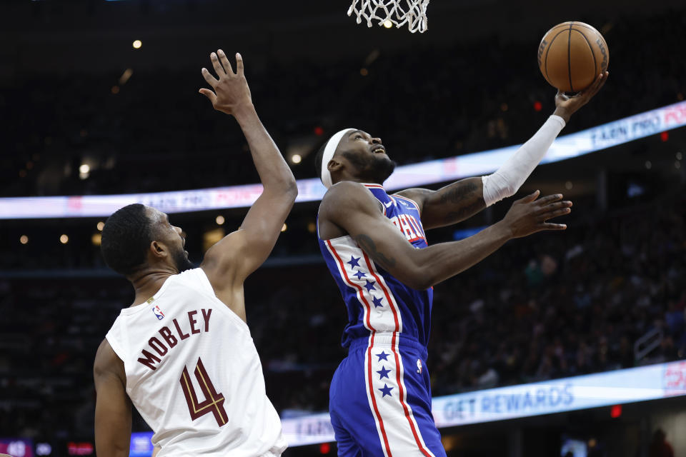 Philadelphia 76ers forward Paul Reed shoots against Cleveland Cavaliers forward Evan Mobley (4) during the first half of an NBA basketball game Friday, March 29, 2024, in Cleveland. (AP Photo/Ron Schwane)