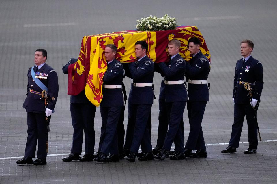 The Queen’s coffin is carried off a plane by the Queen’s Colour Squadron at RAF Northolt (AP Photo/Kirsty Wigglesworth, Pool)