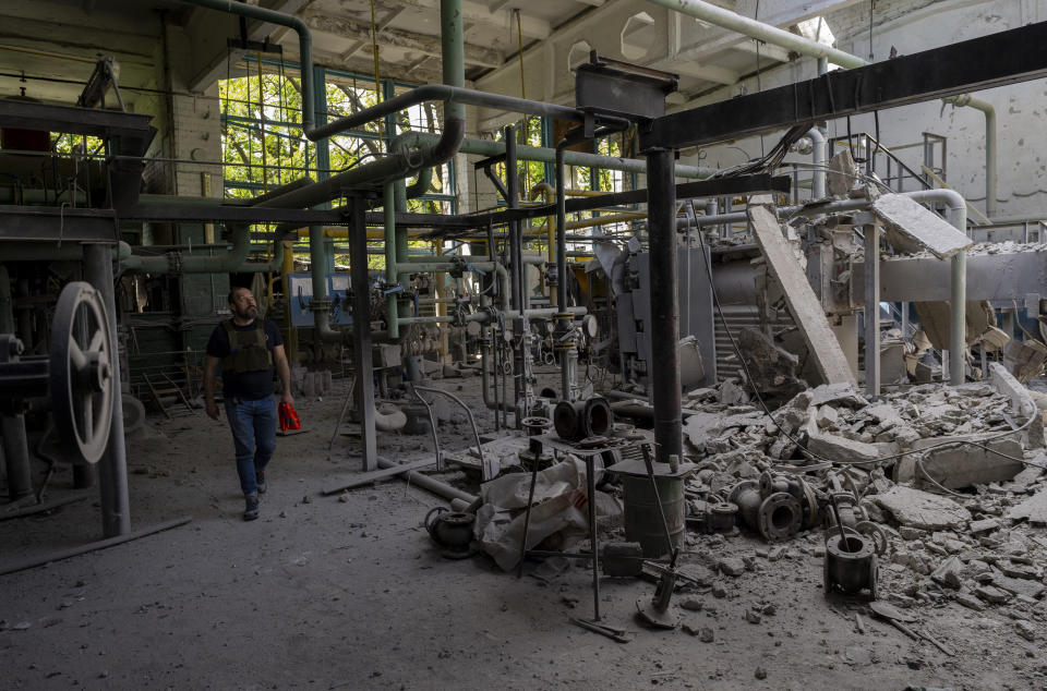 A man inspects the damage of a destroyed boiler room in Kharkiv, eastern Ukraine, Thursday, May 19, 2022. The building was shelled early Thursday. (AP Photo/Bernat Armangue)