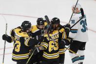 Boston Bruins' Brad Marchand (63) celebrates his goal with teammates as San Jose Sharks' Logan Couture (39) skates away during the first period of an NHL hockey game, Sunday, Oct. 24, 2021, in Boston. (AP Photo/Michael Dwyer)