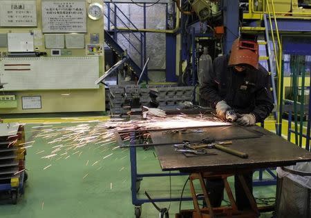 A worker cuts a metal at a sheet metal processing company Yamada Manufacturing in Daito, Osaka prefecture, December 10, 2013. REUTERS/Yoko Kubota