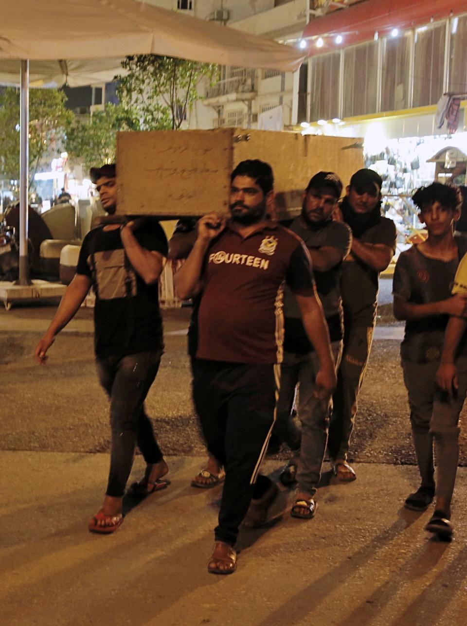 Mourners carry the coffin of Saleh Ahmed, 27, a protester killed during anti-government demonstrations in Najaf, Iraq, Monday, Oct. 28, 2019. (AP Photo/Anmar Khalil)