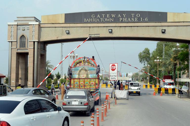 Pakistani motorists drive through the main entrance at the Bahria Town private develpoment in Rawalpindi on October 2, 2013