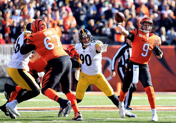 Joe Burrow #9 of the Cincinnati Bengals throws the ball as T.J. Watt #90 of the Pittsburgh Steelers looks to apply pressure during the first quarter at Paul Brown Stadium on November 28, 2021 in Cincinnati, Ohio.