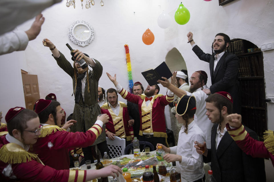 Ultra-Orthodox Jews celebrate during the Jewish holiday of Purim, in the Mea Shearim ultra-Orthodox neighborhood of Jerusalem, Sunday, Feb. 28, 2021. The Jewish holiday of Purim commemorates the Jews' salvation from genocide in ancient Persia, as recounted in the biblical Book of Esther. (AP Photo/Oded Balilty)