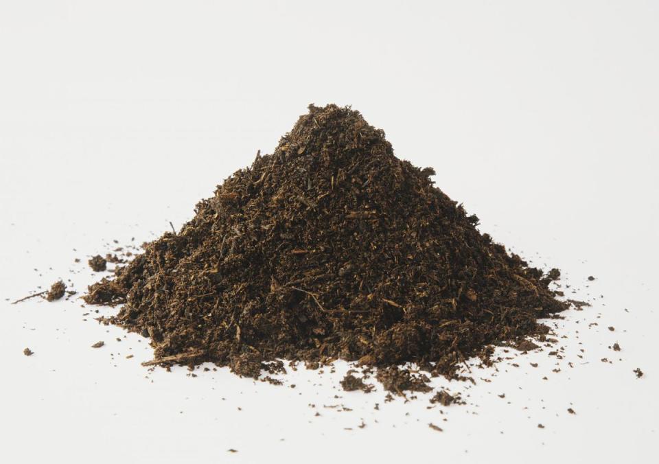 A pile of organic compost on a white background.