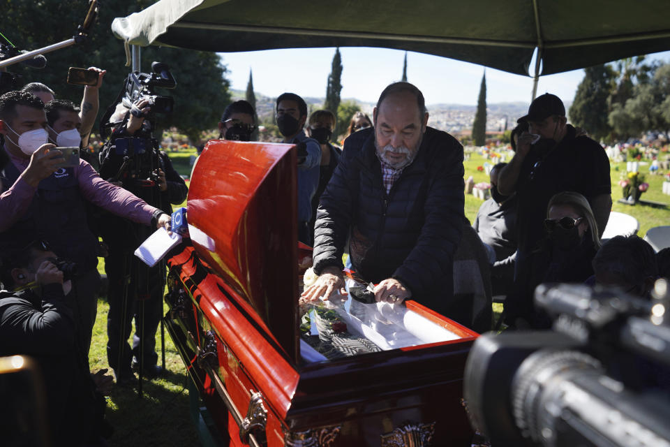 Carlos Maldonado pays his final respects standing over the coffin containing the remains of his sister, murdered journalist Lourdes Maldonado during her burial service at the Monte de los Olivos cemetery in Tijuana, Mexico, Thursday, Jan. 27, 2022. Maldonado, who was shot dead in her car when arriving home on Sunday, Jan. 23, was the third journalist killed in Mexico this year and the second in a space of two weeks in the border town of Tijuana. (AP Photo/Marco Ugarte)