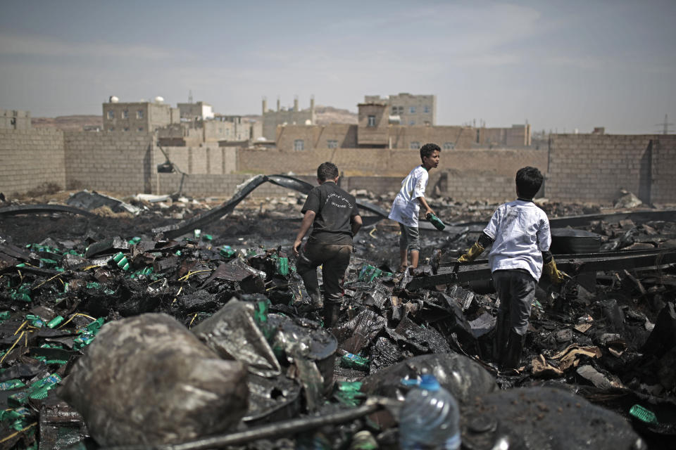 Workers salvage oil canisters from the wreckage of a vehicle oil store hit by Saudi-led airstrikes in Sanaa, Yemen, Thursday, July 2, 2020. (AP Photo/Hani Mohammed)