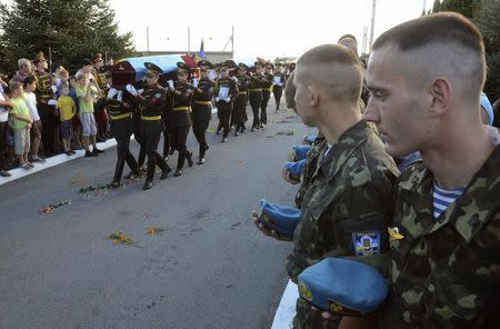 Honour guards carry flag-draped coffins containing the bodies of Ukrainian servicemen killed in action in eastern Ukraine, upon their arrival at the airport in Lviv, August 19, 2014. REUTERS/Roman Baluk