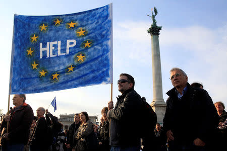 FILE PHOTO: People hold a placard during a protest in Heroes’ square against a new law that would undermine Central European University, a liberal graduate school of social sciences founded by U.S. financier George Soros, in Budapest, Hungary April 12, 2017. REUTERS/Bernadett Szabo