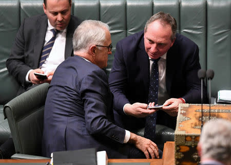 Australian Deputy Prime Minister Barnaby Joyce (R) speaks with Australian Prime Minister Malcolm Turnbull during House of Representatives Question Time at Parliament House in Canberra, Australia August 14, 2017. AAP/Lukas Coch via REUTERS