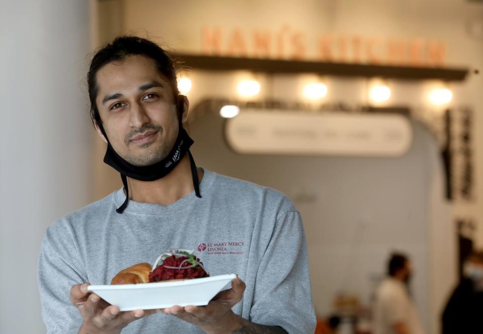 Meghesh Pansari, owner of Nani's Kitchen, holds pav bhaji, the sandwich that launched his restaurant in Mercantile on Main in Sibley Square.