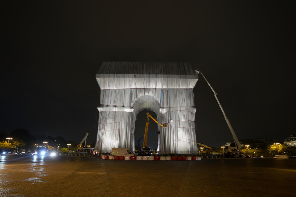 Workers wrap the Arc de Triomphe monument, Wednesday, Sept. 15, 2021 in Paris. The "L'Arc de Triomphe, Wrapped" project by late artist Christo and Jeanne-Claude will be on view from, Sept. 18 to Oct. 3. The famed Paris monument will be wrapped in 25,000 square meters of fabric in silvery blue, and with 3,000 meters of red rope. (AP Photo/Francois Mori)