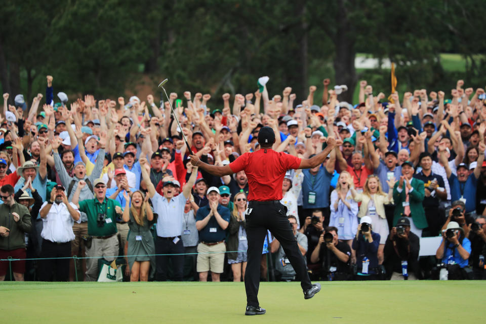 AUGUSTA, GEORGIA - APRIL 14: Patrons cheer as Tiger Woods of the United States celebrates after sinking his putt on the 18th green to win during the final round of the Masters at Augusta National Golf Club on April 14, 2019 in Augusta, Georgia. (Photo by David Cannon/Getty Images)