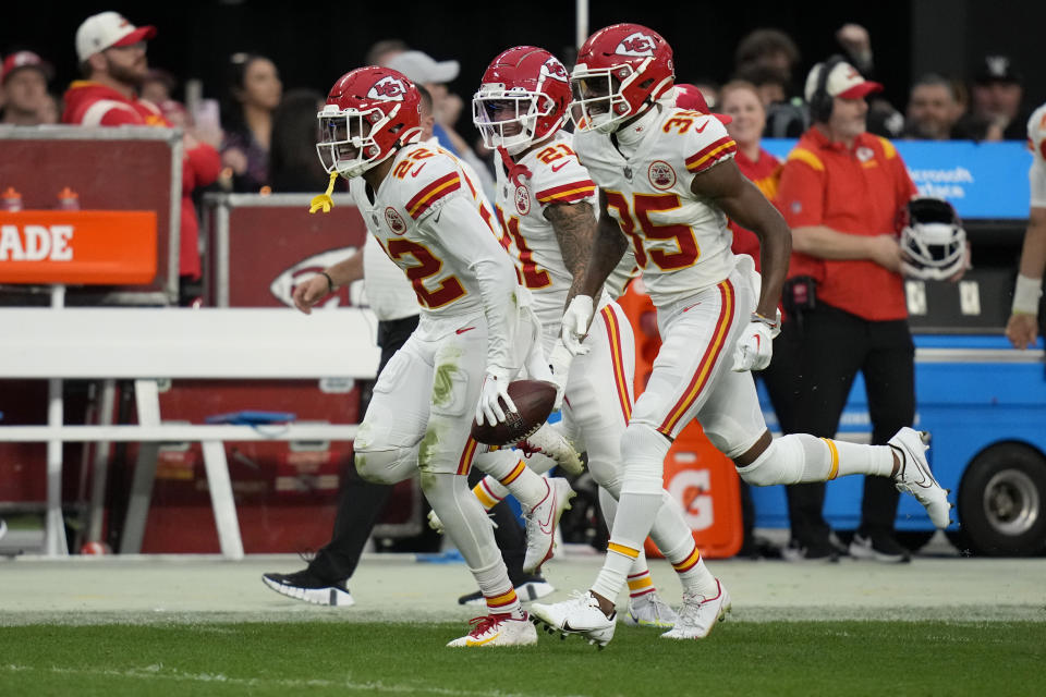 Kansas City Chiefs safety Juan Thornhill, left, celebrates with teammates Trent McDuffie (21) and Jaylen Watson (35) after intercepting a pass during the first half of an NFL football game against the Las Vegas Raiders Saturday, Jan. 7, 2023, in Las Vegas. (AP Photo/John Locher)