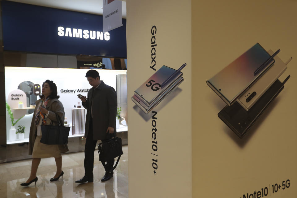 People pass by an advertisement of Samsung Electronics' Galaxy 5G Note10 smartphones at its shop in Seoul, South Korea, Thursday, Oct. 31, 2019. Samsung Electronics said it operating profit for the last quarter fell by nearly 56%, with its robust sales of smartphone, displays and TVs offset by a continuously weak market for computer chips. (AP Photo/Ahn Young-joon)